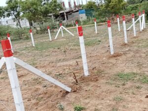 Fence posts with support struts on open land, Chennai
